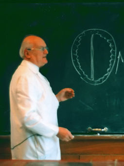 Prof. Otto Prokop bei seiner letzten Vorlesung 1991 in der Charité Berlin (Institut für Physiologie) beim Erklären des Coup-Contrecoup-Mechanismus beim Schädel-Hirn-Trauma.